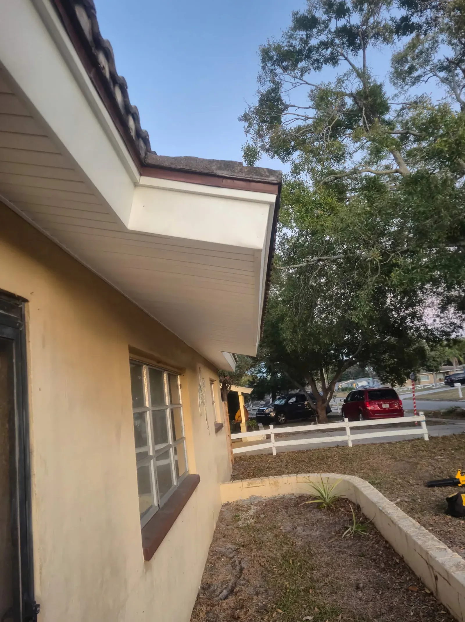Clean white soffit and fascia under a Spanish tile roof on a Tampa Bay stucco home