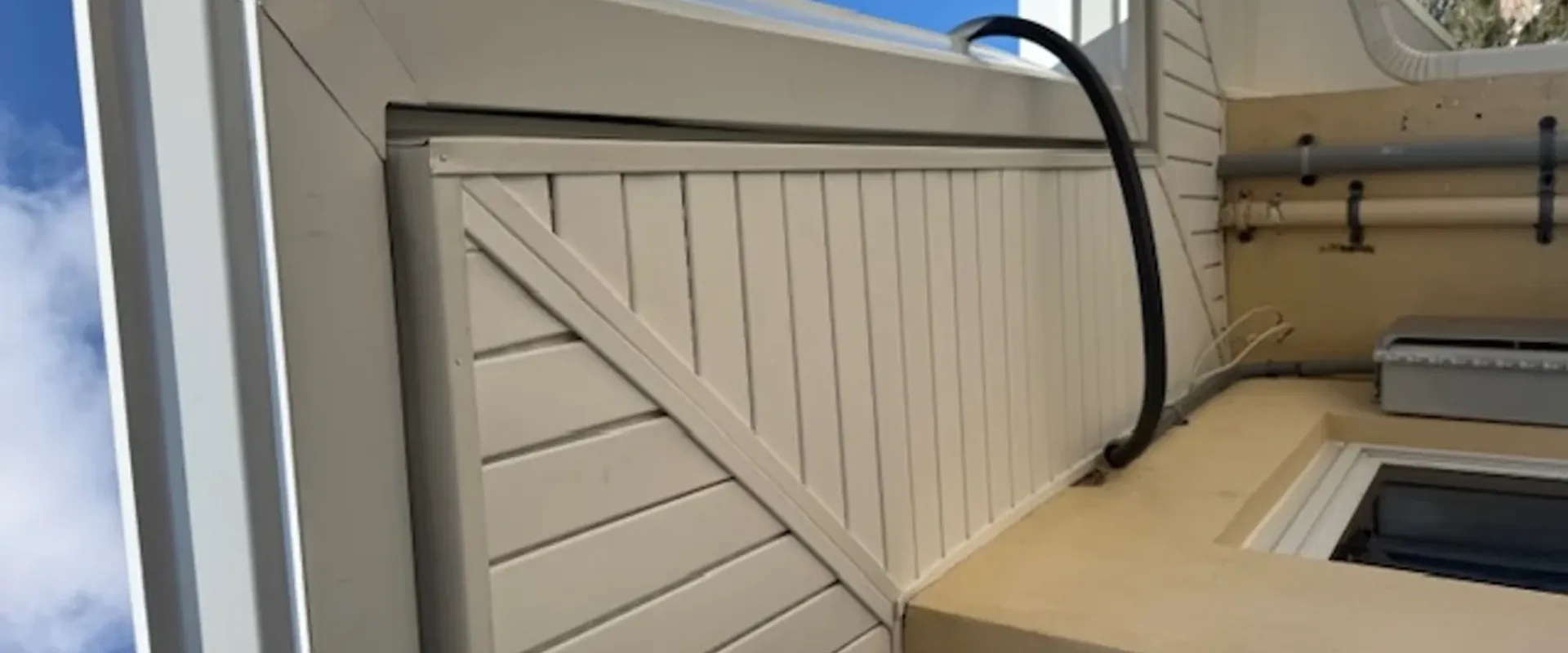 Precision mitered corner detail on a white vented soffit at a gable, showing the angled cuts where roof meets fascia