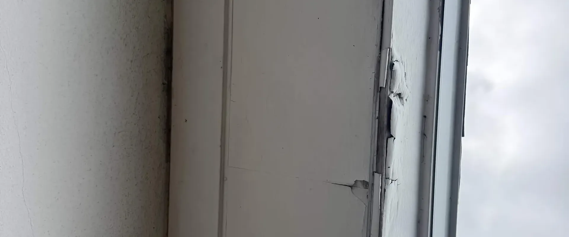 Close-up of cracked and peeling paint on a Tampa Bay home fascia board