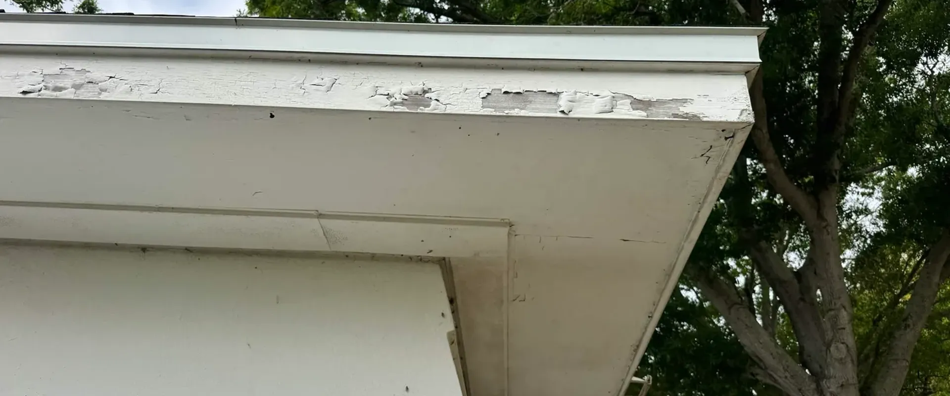 Peeling paint at a gable corner on a Tampa Bay home before fascia wrap